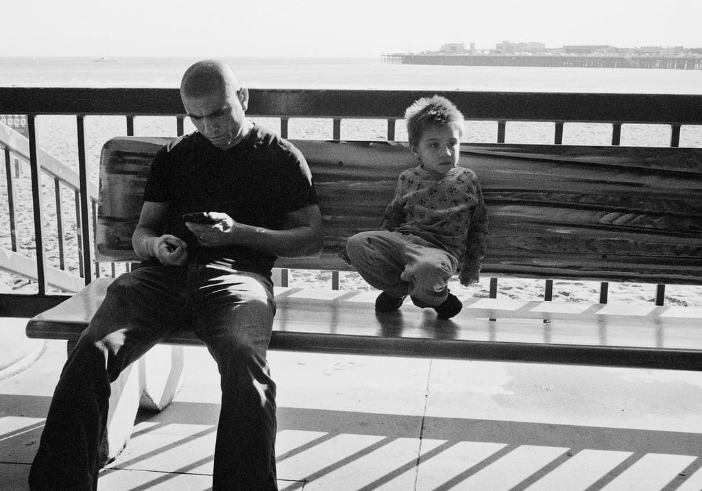 dad who is not engaged with his son on boardwalk