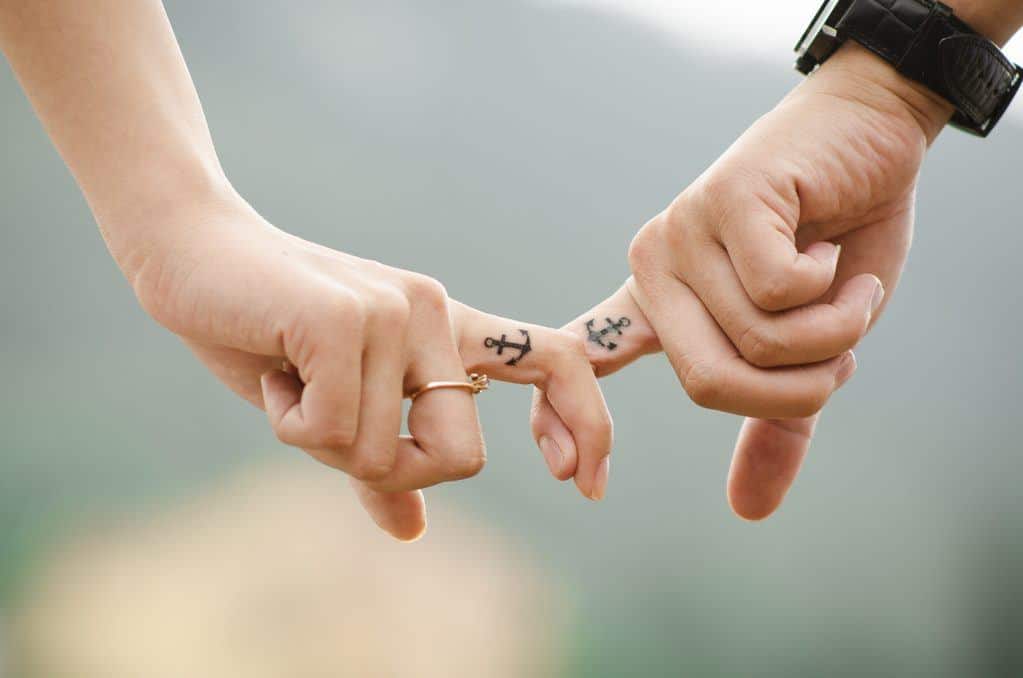 couple locking fingers with anchor tatoos; how to have a healthy marriage