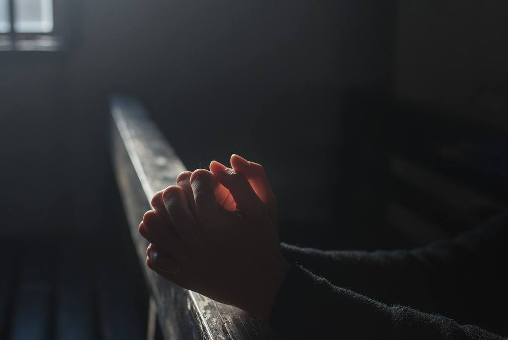 man praying in pew