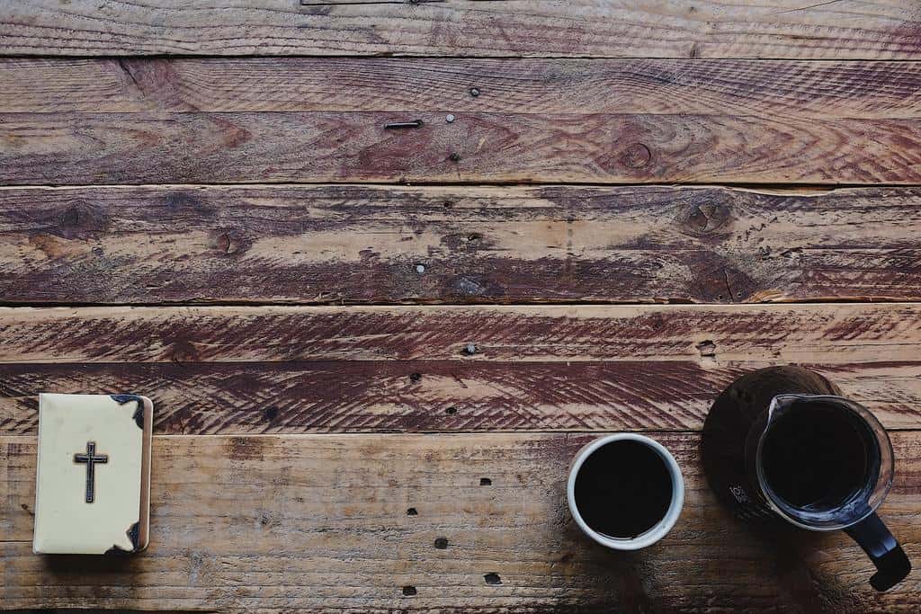 bible on wooden table with coffee mug